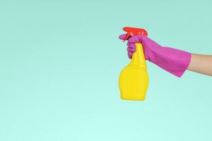 a person wearing a glove holding spray bottle
