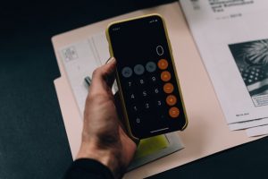 a person holding phone with calculator app open