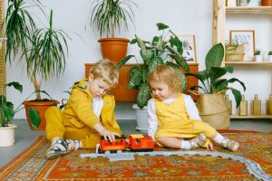 little boy and girl playing with toy cars